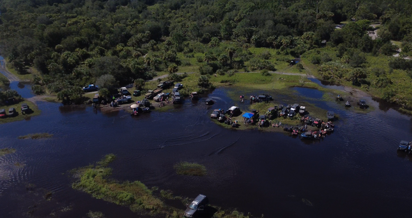 Aerial view of several off-road groups around a flooded riding area